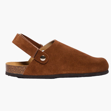 Dark brown suede clog with cork sole and adjustable back velcro strap, displayed on a white background.